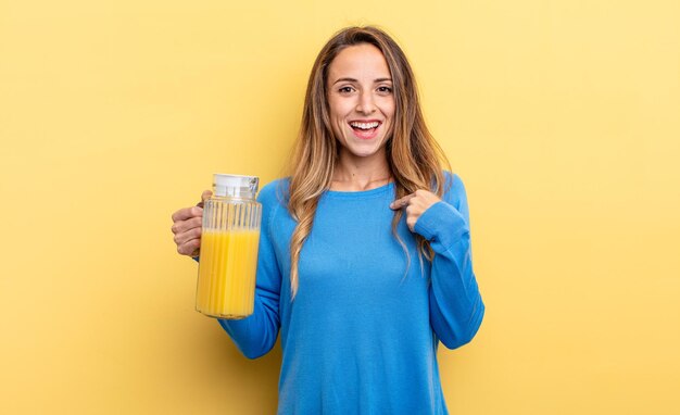 Ładna kobieta czuje się szczęśliwa i wskazuje na siebie z podekscytowaną koncepcją soku pomarańczowego