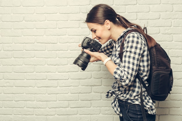 Ładna kobieta jest profesjonalnym fotografem z aparatem dslr