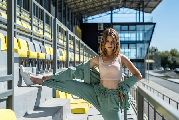 Ładna kobieta robi ćwiczenia rano relaksu na trybunie stadionu