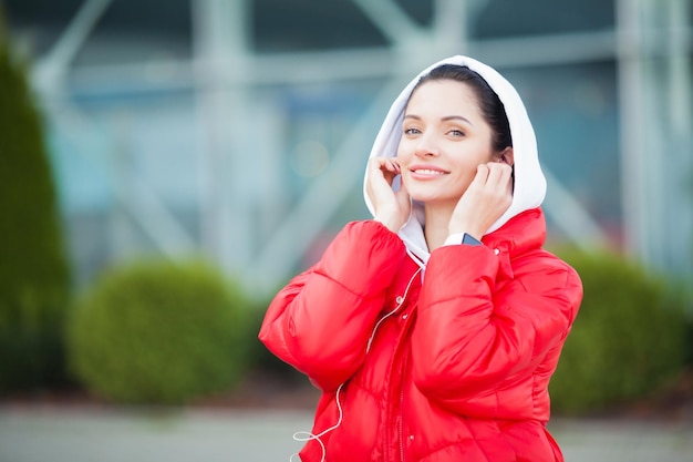 Ładna kobieta robi fitness na świeżym powietrzu, słuchając muzyki