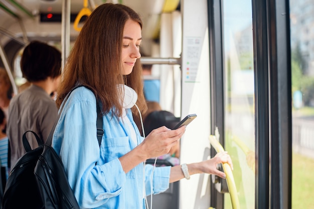 Ładna Kobieta Siedzi Z Smartp Hone, Poruszając Się Nowoczesnym Tramwajem Lub Metrem. Wycieczka Transportem Publicznym.