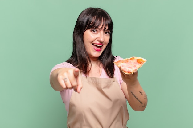 Ładna Kobieta Szefa Kuchni Wskazująca Lub Pokazująca I Trzymająca Pizzę?