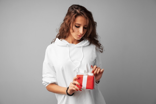 Ładna kobieta trzyma czerwone pudełko w dłoniach