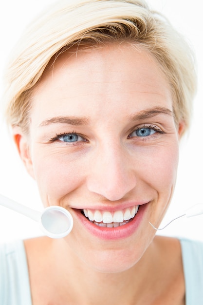 Zdjęcie Ładna kobieta trzyma stomatologicznych narzędzia