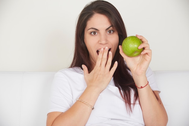 Ładna kobieta trzyma zielone jabłko