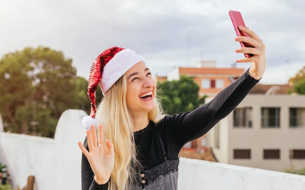 Ładna kobieta vlogging z telefonu komórkowego na Boże Narodzenie.