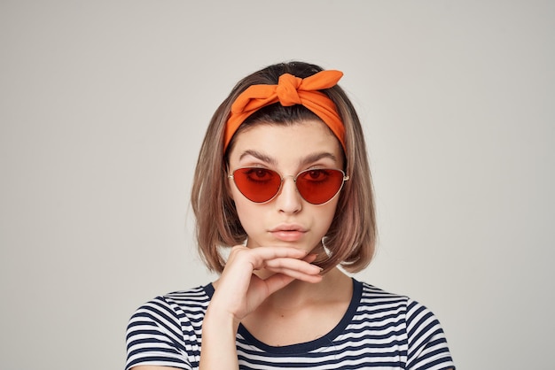 Ładna kobieta w okularach przeciwsłonecznych z bandażem na głowie w nowoczesnym stylu jasnym tle