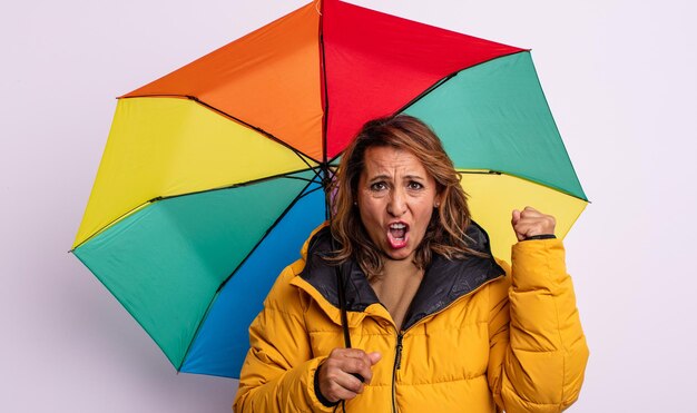 Ładna kobieta w średnim wieku, krzycząca agresywnie z gniewnym wyrazem twarzy. koncepcja parasola