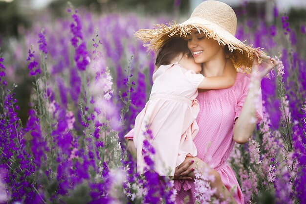 Ładna mała dziewczynka i jej matka z kwiatami. Rodzina na zewnątrz