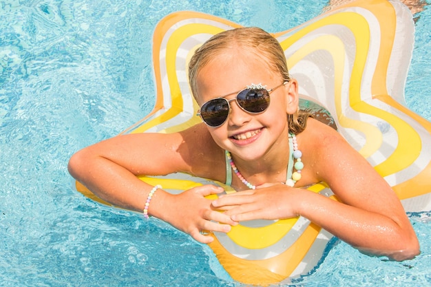 Ładna mała dziewczynka w pływackim basenie, wakacje.