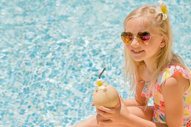 Ładna mała dziewczynka w pływackim basenie, wakacje.