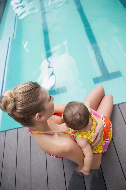 Ładna matka i dziecko przy pływackim basenem