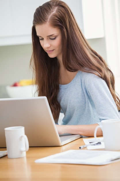 Ładna młoda dziewczyna używa laptop