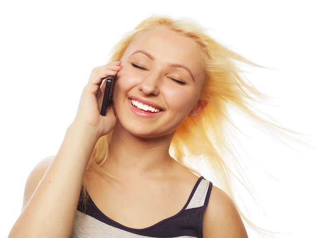 Ładna młoda kobieta korzystająca z telefonu komórkowego na białym tle