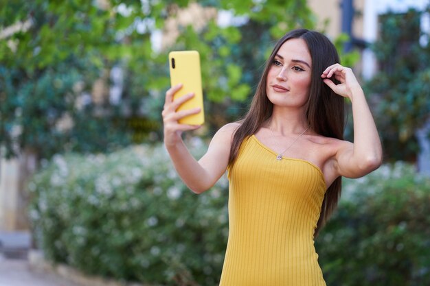 Ładna młoda kobieta robi selfie smartfonem