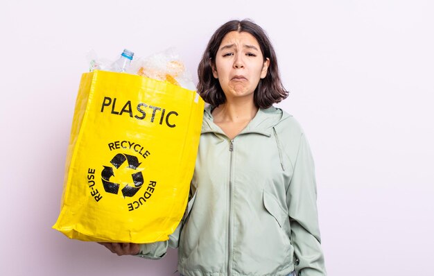 Ładna młoda kobieta, smutna i jęcząca, z nieszczęśliwym spojrzeniem i płaczem. koncepcja recyklingu tworzyw sztucznych