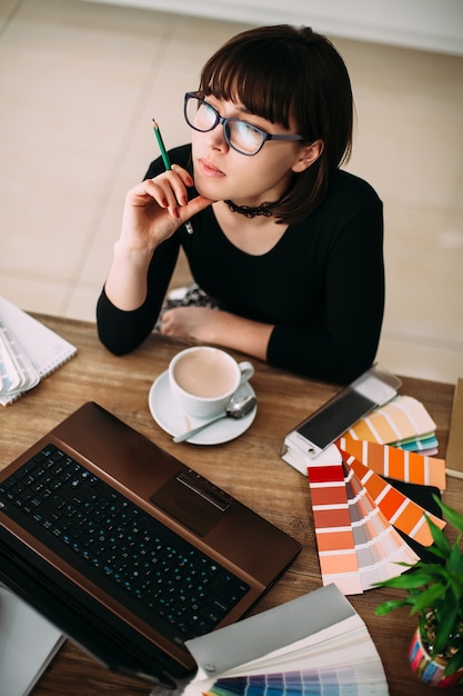 Zdjęcie Ładna młoda kobieta używa laptop przy biurem