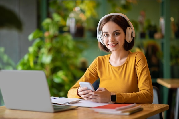 Ładna Młoda Kobieta Używa Słuchawek I Laptopa Pracującego Online