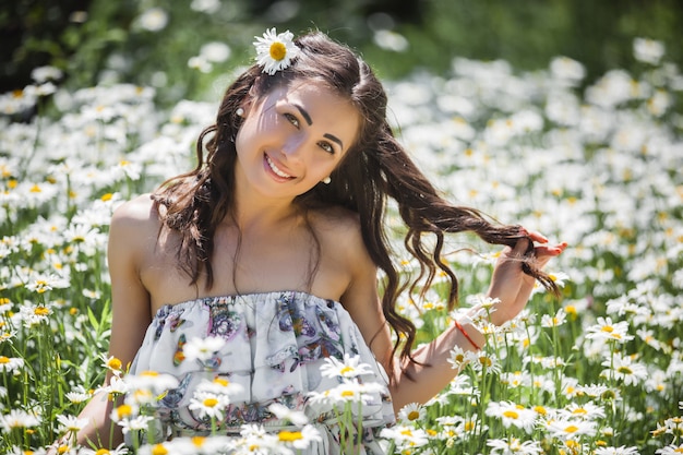 Ładna młoda kobieta w rumianku polu. Piękna dziewczyna z kwiatami