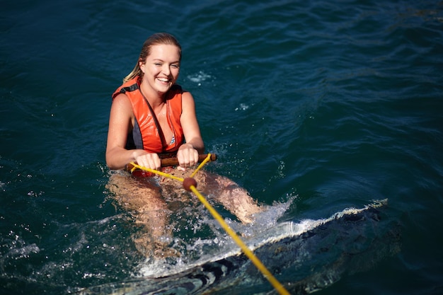 Ładna młoda kobieta w wodzie z wakeboardem w kamizelce ratunkowej Ładna młoda kobieta w wodzie z wakeboardem w kamizelce ratunkowej