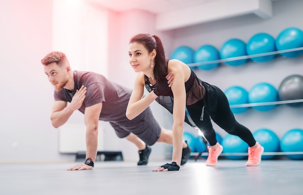 Ładna młoda para robi ćwiczeniom w lekkim gym wpólnie.