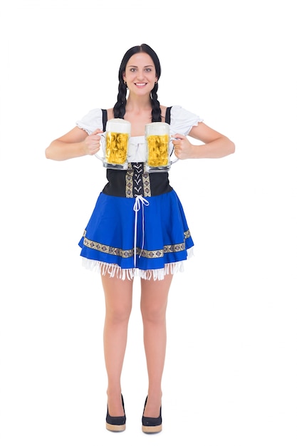 Ładna oktoberfest dziewczyna trzyma piwnych tankards