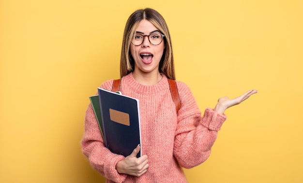 Ładna studentka czuje się szczęśliwa, zaskoczona, gdy realizuje rozwiązanie lub pomysł. książki i plecak