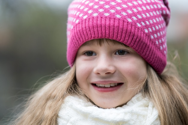 Ładne dziecko dziewczynka w ciepłe zimowe ubrania z dzianiny na zewnątrz.