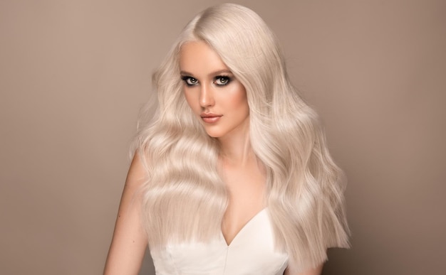 Ładnie wyglądający młody model z długimi włosami ufarbowanymi w odcieniach blondu i srebra. Makijaż fryzjerski