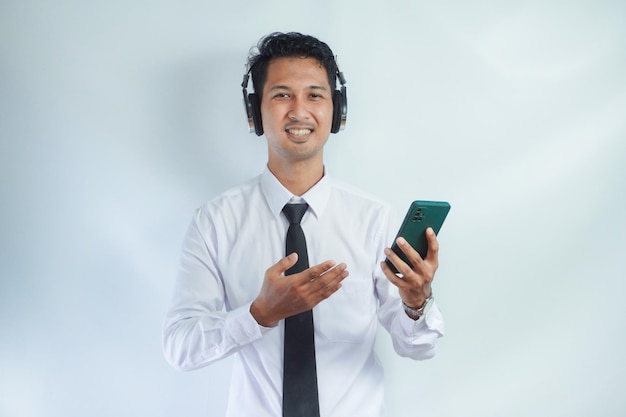 Zdjęcie Ładny azjat słucha muzyki za pomocą telefonu komórkowego i bezprzewodowych słuchawek