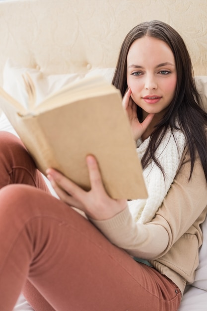 Ładny brunetki czytanie na jej łóżku