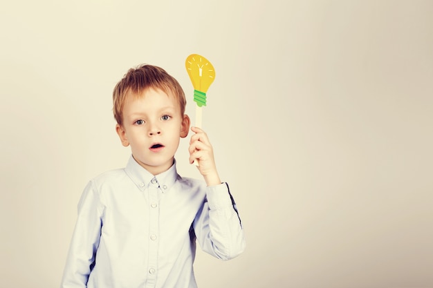 Zdjęcie Ładny chłopak z żółtą papierową żarówką
