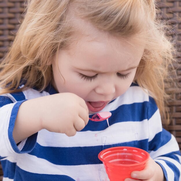 Zdjęcie Ładny chłopczyk je smaczne lody w kawiarni na świeżym powietrzu