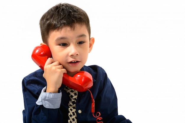 ładny chłopiec rozmawia stary telefon i patrzy w dół