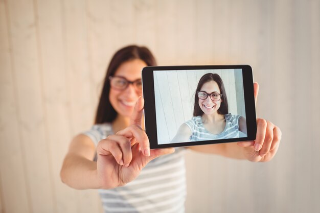 Zdjęcie Ładny hipster biorąc selfie z tabletem