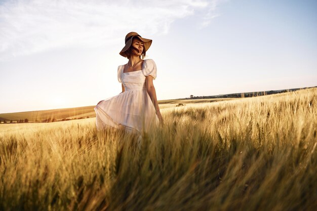 Ładny krajobraz Piękna panna młoda w białej sukience jest na polu rolnym w słoneczny dzień