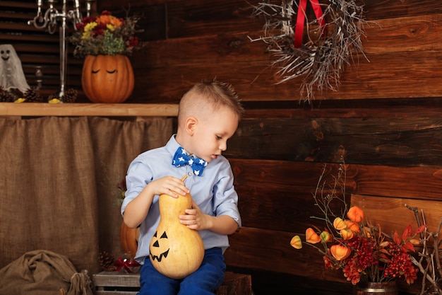 Ładny mały chłopiec bawi się w dekoracje na Halloween