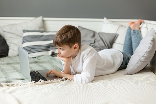 Ładny mały chłopiec za pomocą laptopa w domu Edukacja online nauka w domu nauka na odległość szkoła chłopiec dzieci koncepcja stylu życia