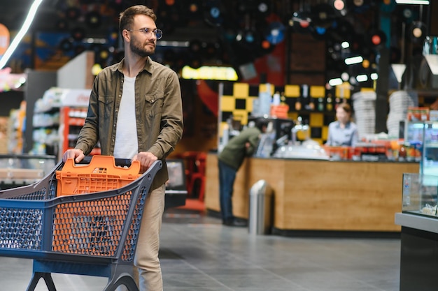 Ładny mężczyzna robi zakupy w supermarkecie.