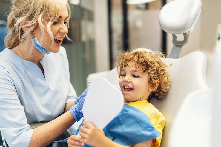 Zdjęcie ładny młody chłopak odwiedzający dentystę i sprawdzający jego zęby przez dentystę w gabinecie stomatologicznym
