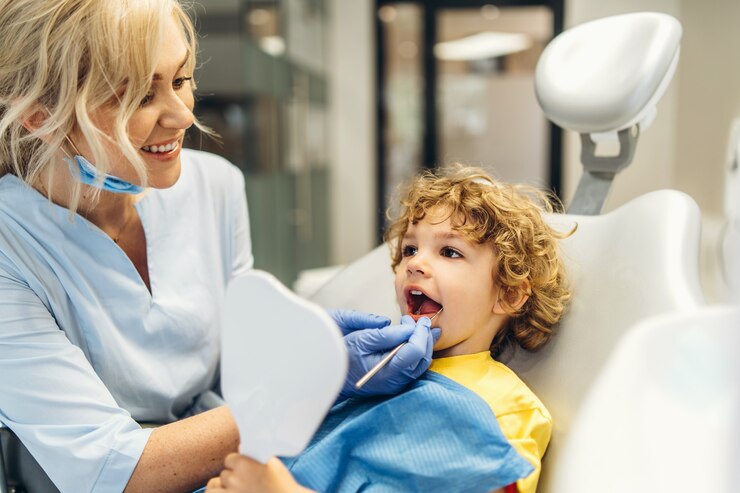 Zdjęcie ładny młody chłopak odwiedzający dentystę, po sprawdzeniu zębów przez kobietę dentystę w gabinecie stomatologicznym.