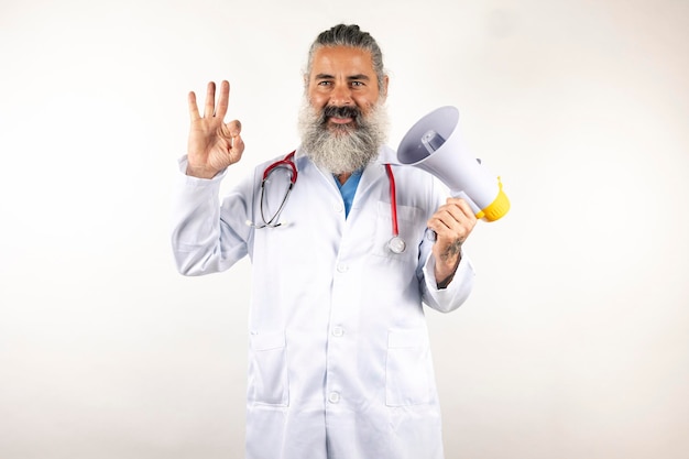 Ładny nowoczesny lekarz z megafonem na izolowanym białym tle robi OK znak palcami