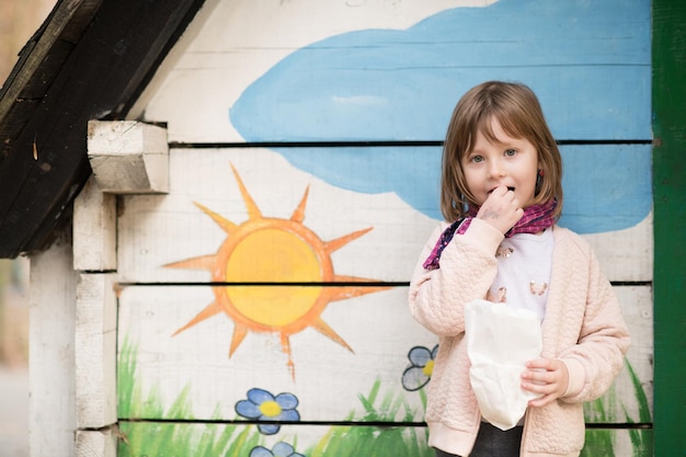 ładny portret małej dziewczynki podczas zabawy w parku zabaw w pochmurny jesienny dzień