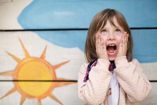 ładny portret małej dziewczynki podczas zabawy w parku zabaw w pochmurny jesienny dzień