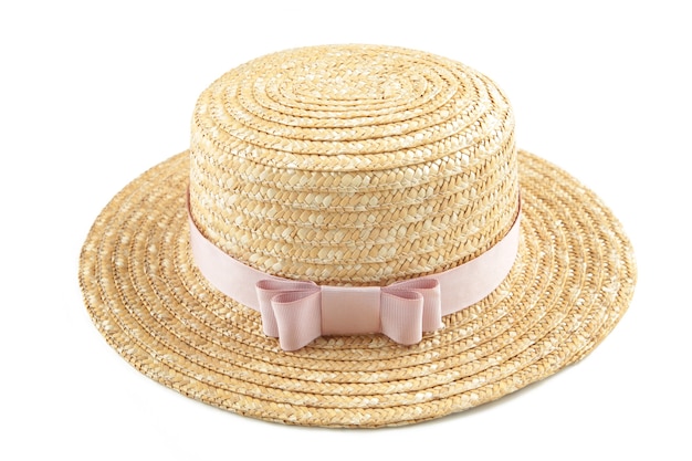 Ładny słomkowy kapelusz z różową wstążką na białym tle na białej powierzchni