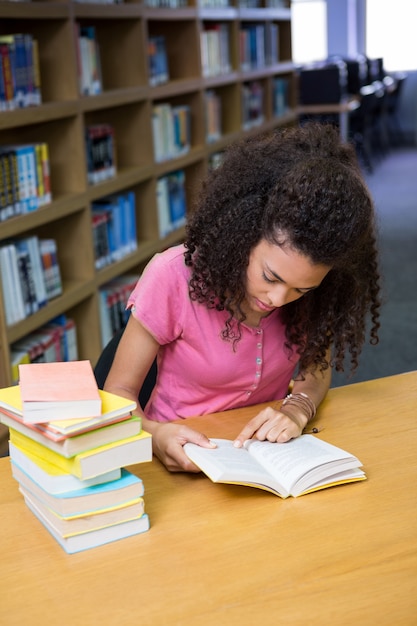 Ładny studencki studiowanie w bibliotece