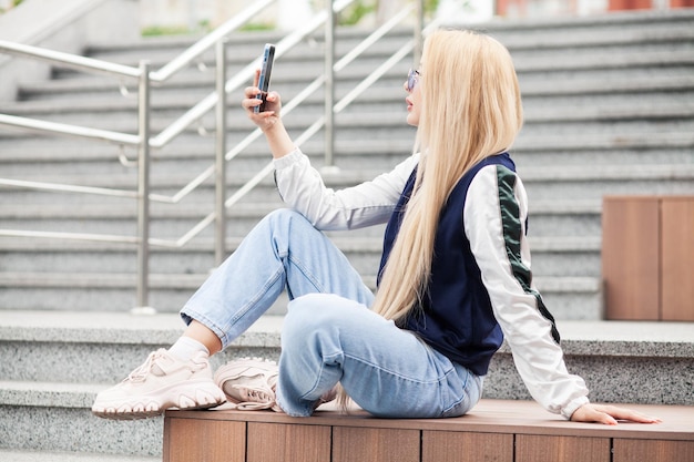 Ładny szczęśliwy piękna młoda kobieta sprawia, że selfie na smartfonie.