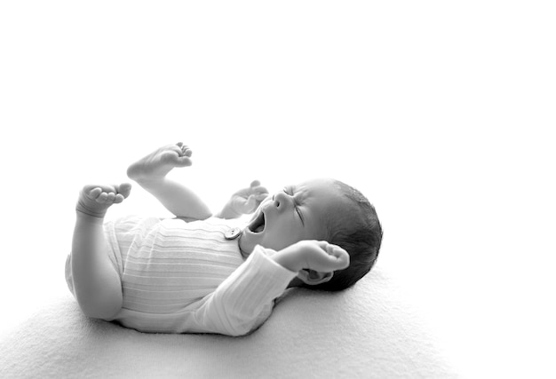 Ładny zdrowy noworodek z zamkniętymi oczami ziewa, z bliska, głowa dziecka i twarz w profilu, białe tło, nieostrość
