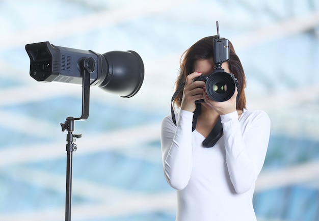 Ładny żeński fotograf pracuje w studiu