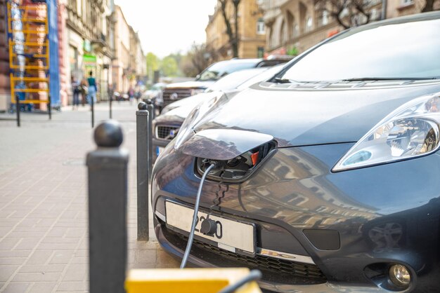 Ładowanie samochodu elektrycznego na parkingu przy ulicy miejskiej